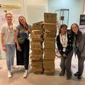 Four members of the Preston lab stand either side of two head high pizza box stacks at the end of the ECPP24 reception in September 2024